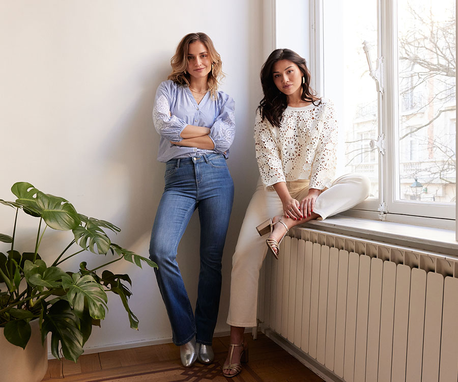 Model wearing a blue shirt on jeans and model wearing white shirt on white pants